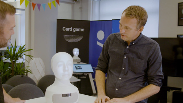 Två personer i ett stort rum med ett VR headset.