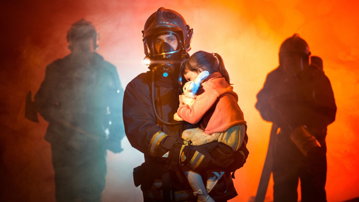 Firefighter carrying a child.