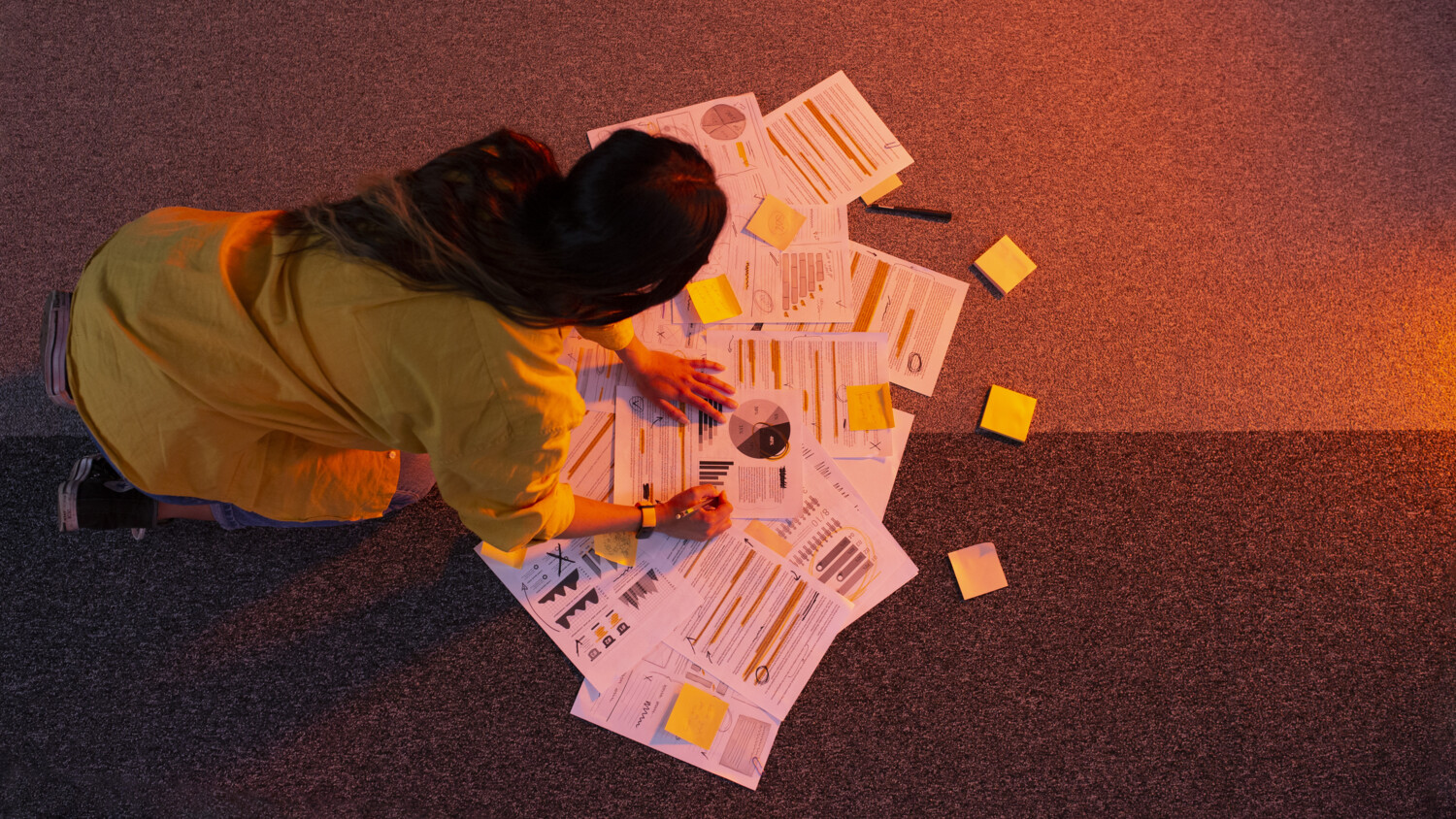 Woman working on different ideas using notes and post-its.