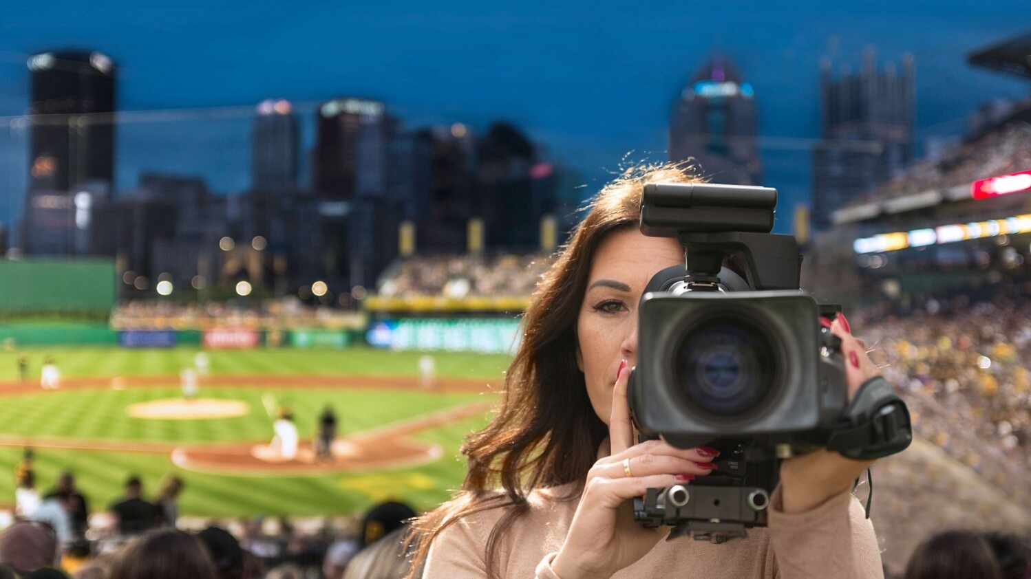 Reporter at stadium broadcasting with 5G camera equipment.