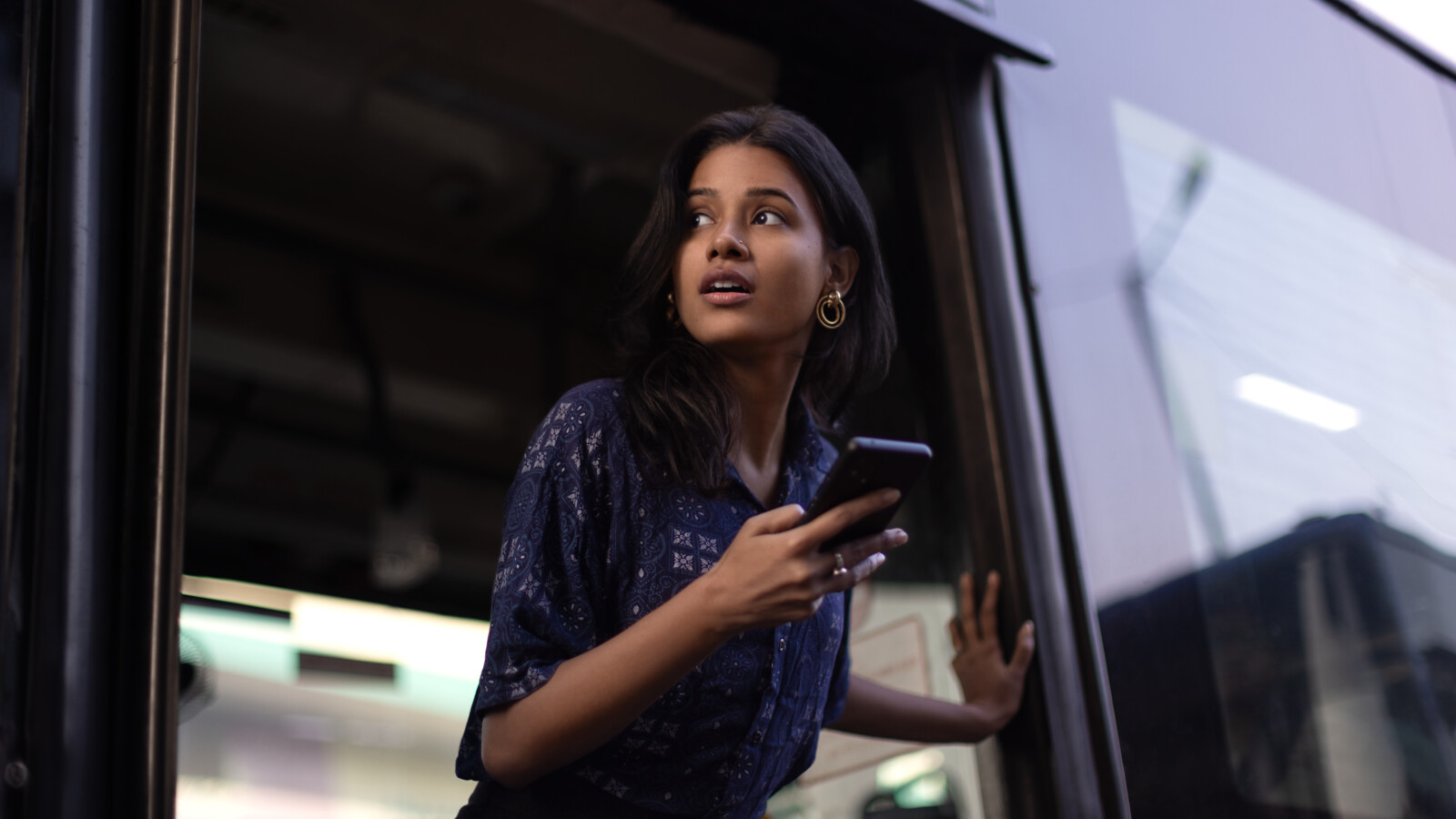 Woman with phone stepping of bus