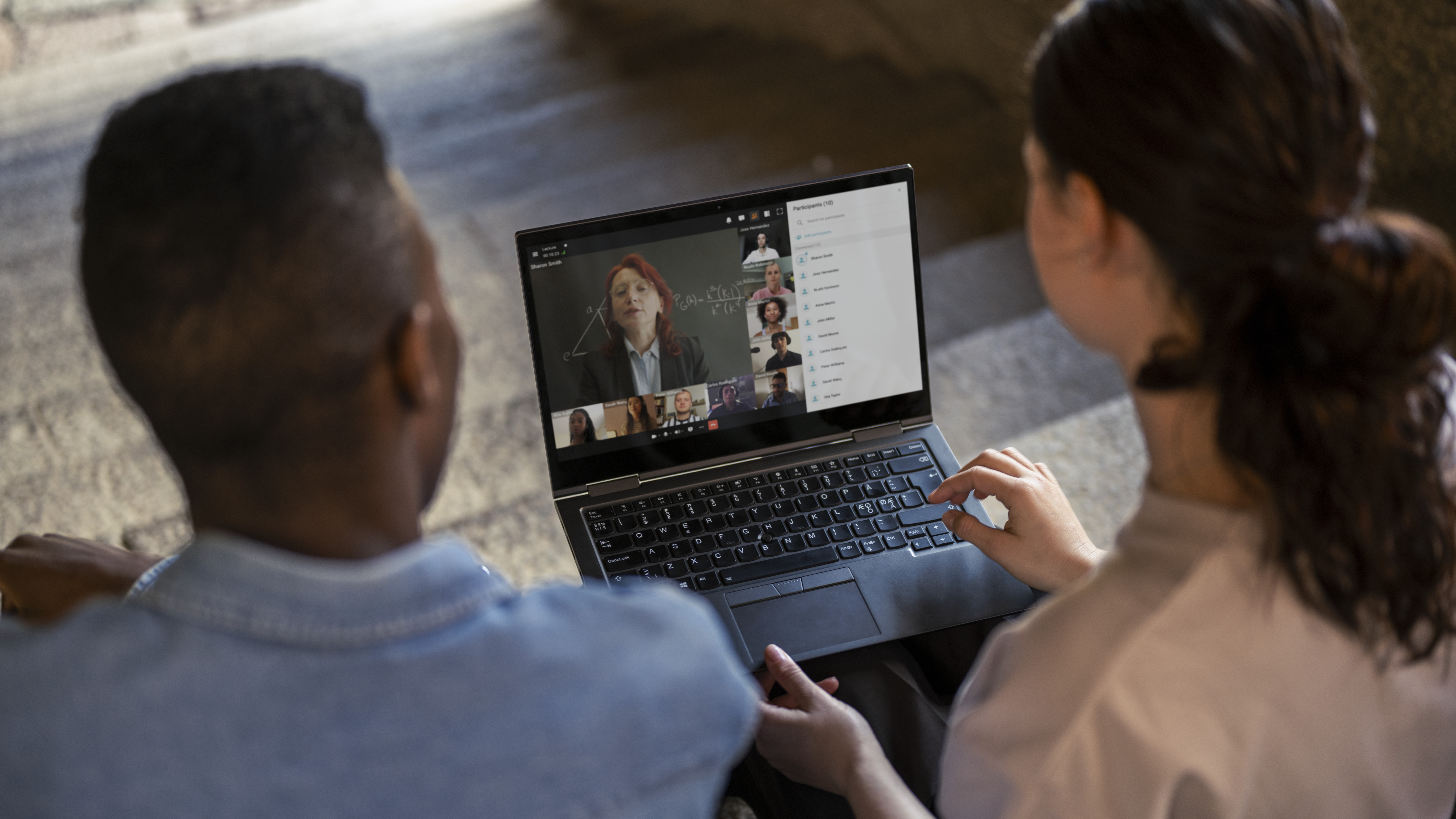 Two persons with a laptop on a video call meeting.