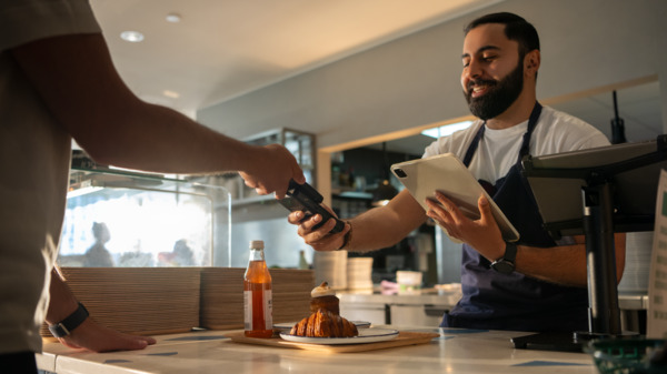 Person paying with mobile phone at a restaurant.