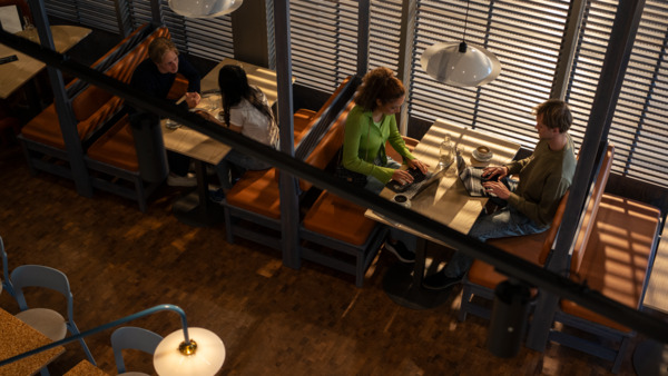 Customers in a cafe with laptops using wifi.