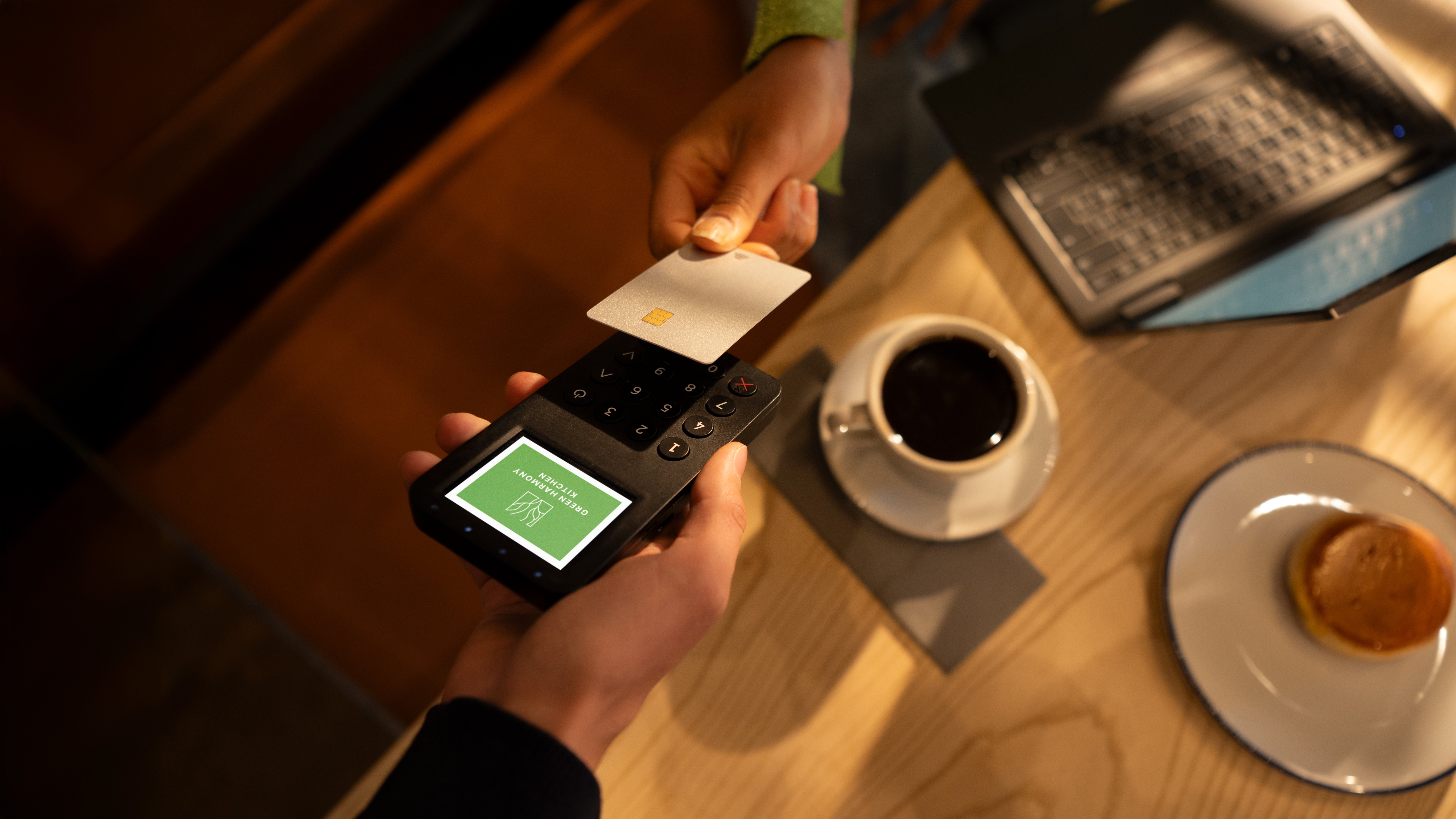Person paying in a cafe with a credit card.