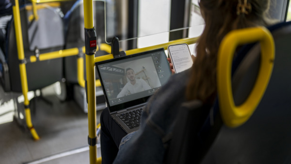 Person using a laptop on the bus.