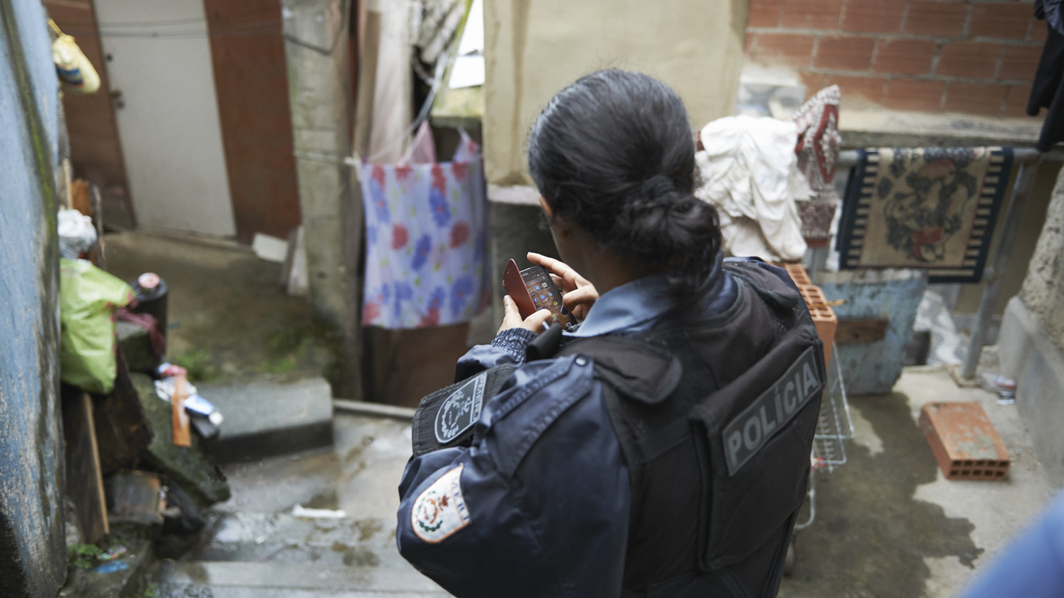 Police in police uniform wearing bulletproof jacket and using mobile phone